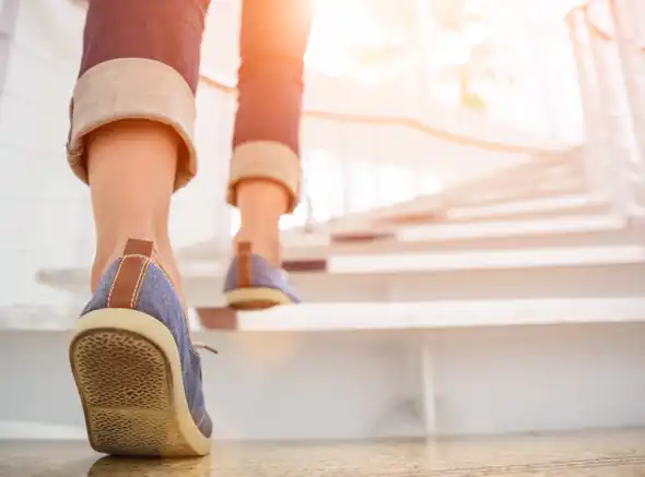 Delivery person walking up white stairs